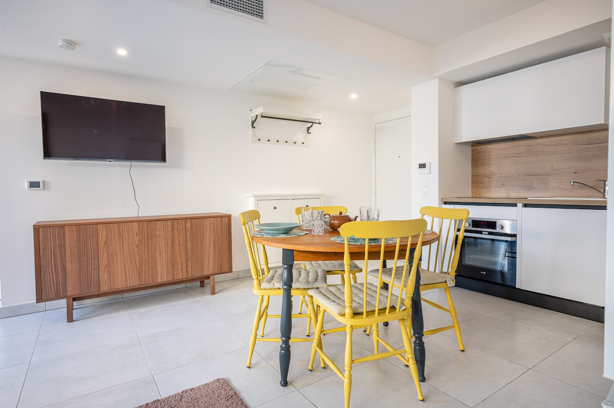Dining area with yellow chairs and Smart TV