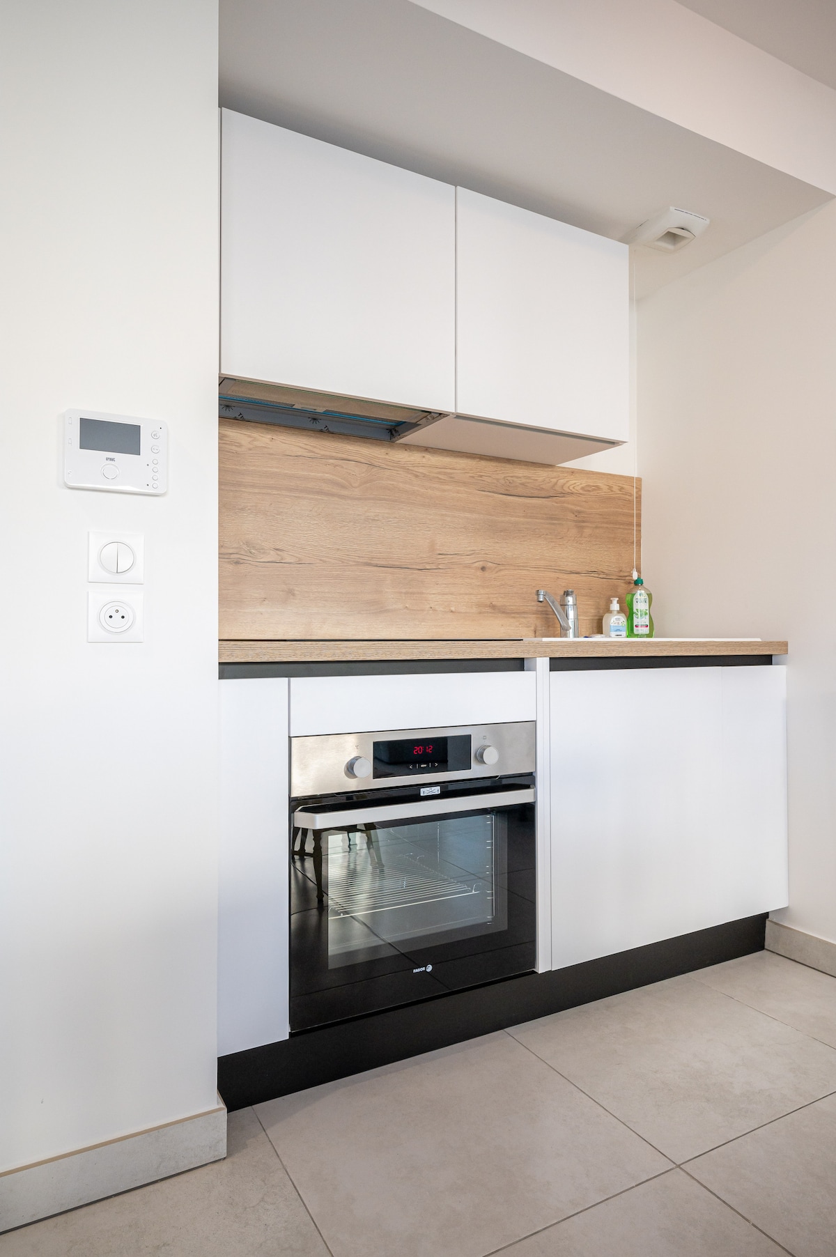 Kitchen with oven, hood and oak backsplash