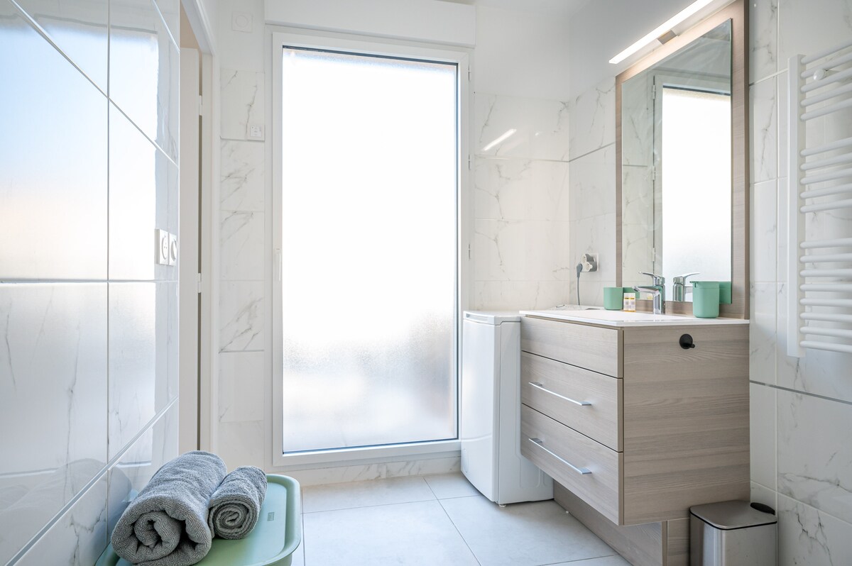 Bathroom with shower, vanity and natural light